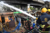 PATNA, MAY 4 (UNI):- Firefighters dousing a fire which broke out in the slums, near Chitkohra area, in Patna on Saturday. UNI PHOTO-93U